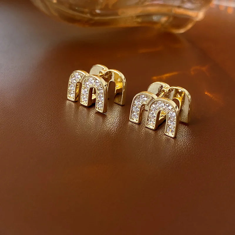 Gouden M Kristal Oorbellen | Sensia