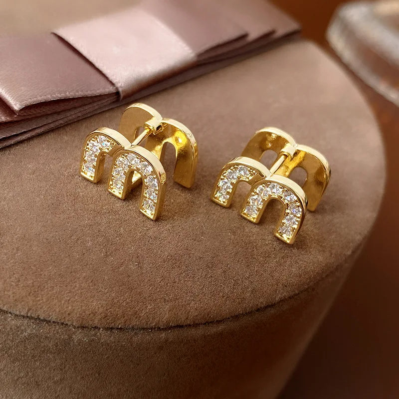 Gouden M Kristal Oorbellen | Sensia